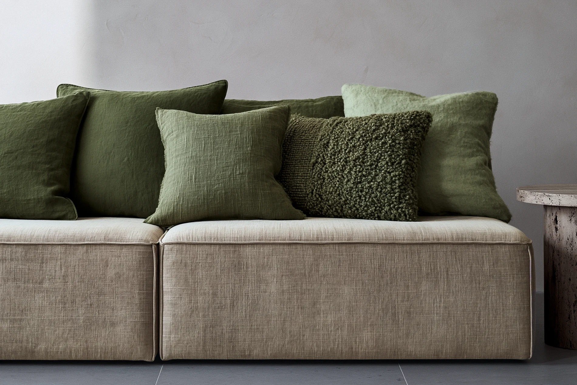 Five green cushions in one colour family and several distinct surfaces.