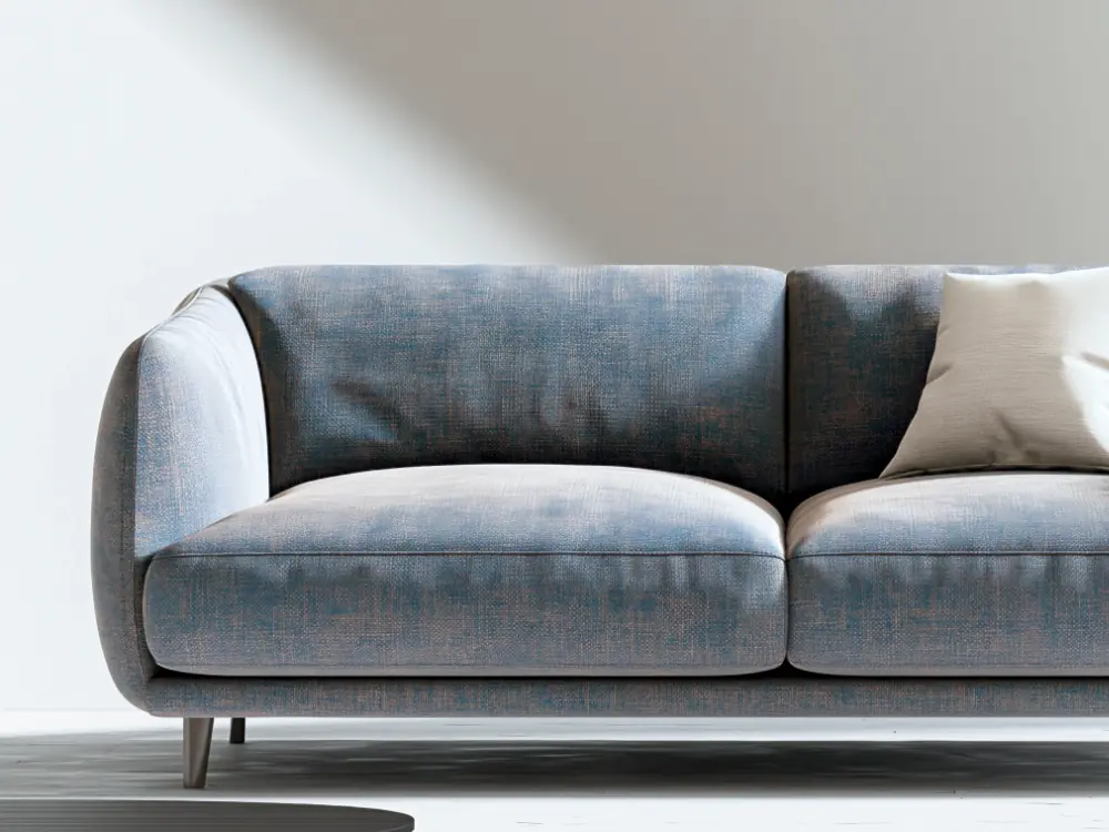 Close view of a blue-grey woven sofa with a cushion, in soft daylight.